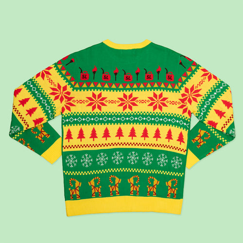 Grön stickad jultröja med mönster av julbocken, granar och gula detaljer från Svenskhusman.