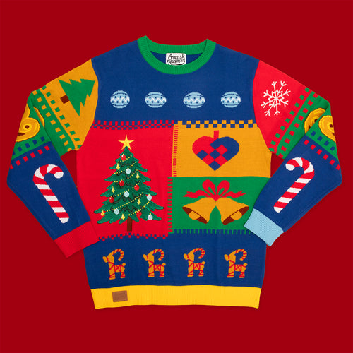 Färgglad stickad jultröja med färgpatch-mönster och julmotiv från Svenskhusman på röd bakgrund.