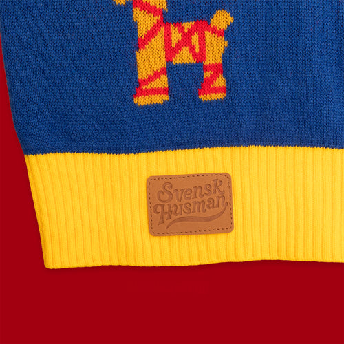 Blå och gul stickad jultröja i färgpatch-design med logotyp i läder på mudden från Svenskhusman.