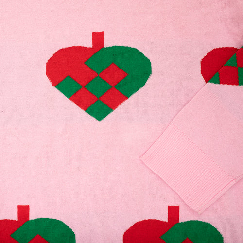 Rosa stickad jultröja med mönster av flätade julhjärtan i rött och grünt från Schwedischhusman.