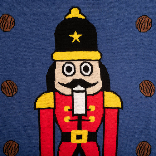 Stickad blå jultröja med motiv av Nötknäpparen i rött och svart samt bruna nötter från Svenskhusman.