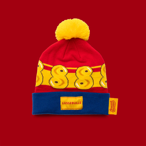 Mössa med lussebullemotiv, gul pom-pom och blå uppvikt kant från Svenskhusman.
