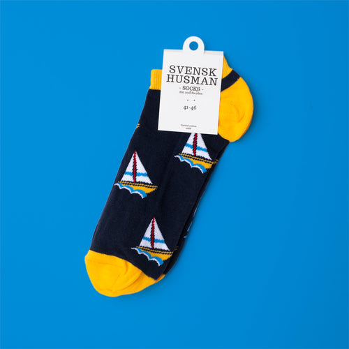 Mörkblå sneakersstrumpor i kammad bomull med gula detaljer och mönster av segelbåtar från Svenskhusman.