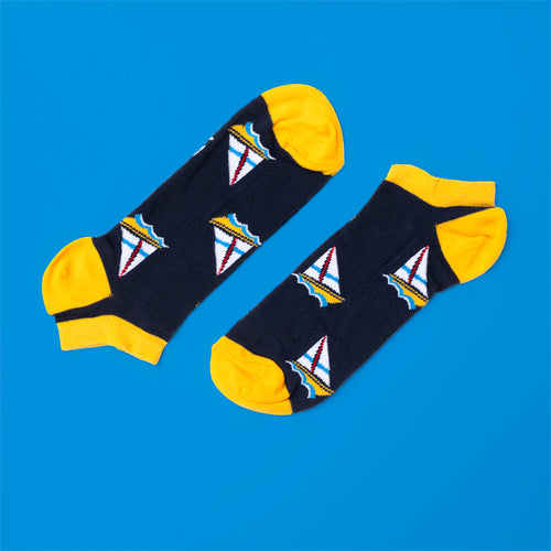 Mörkblå sneakersstrumpor med gula detaljer och ett mönster av vita segelbåtar från Svenskhusman.