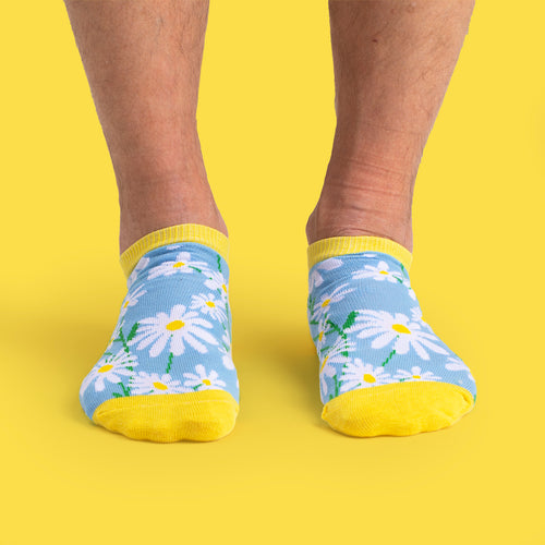 Blå sneakersstrumpor med mönster av vita prästkragar och gula detaljer - Svenskhusman