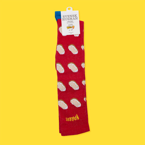Röda stödstrumpor med Kalles kaviar smörgås-motiv från Svenskhusman på en gul bakgrund.
