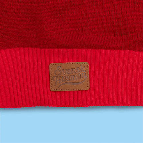 Red knitted Christmas sweater featuring a ribbed hem and brown leather logo patch by Svenskhusman.