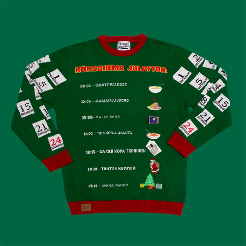 Grön jultröja med ett tryckt körschema för julafton och röda detaljer, från Svenskhusman.