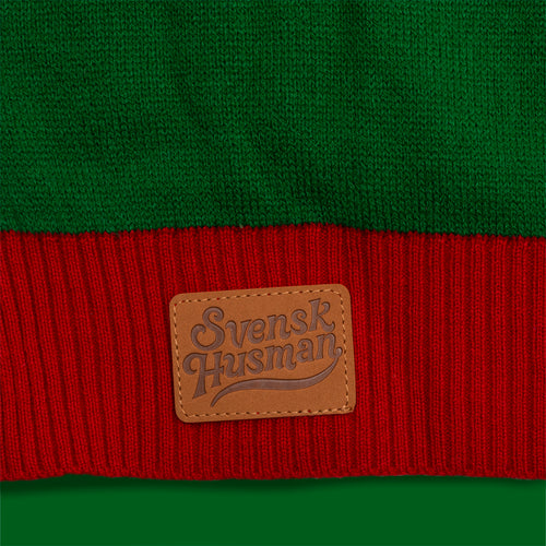 Grün-roter Strick-Weihnachtspullover mit braunem Leder-Patch und Svenskhusman-Logo.
