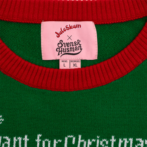Pink neck label detail on a green Juleskum Christmas sweater with a red ribbed collar by Svenskhusman.