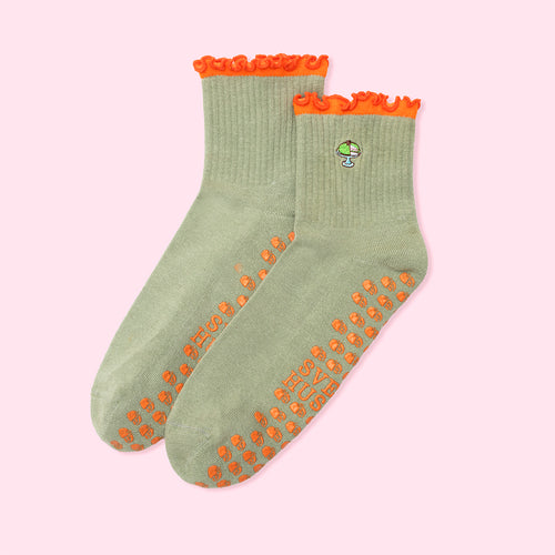Gröna pilatesstrumpor med prinsesstårta-motiv, orange halkskydd och vågig kant från Svenskhusman.