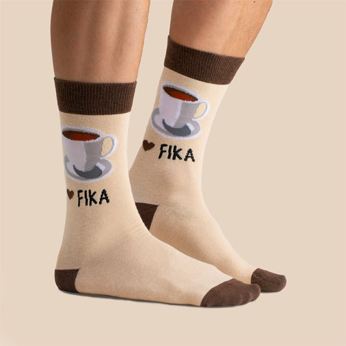 Beige strumpor med mönster av en kaffekopp och texten Fika - Svenskhusman