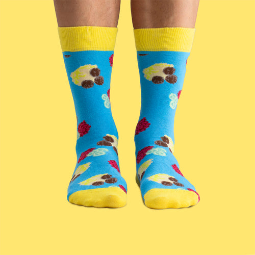 Blue and yellow socks with a pattern of meatballs and mashed potatoes by Svenskhusman.