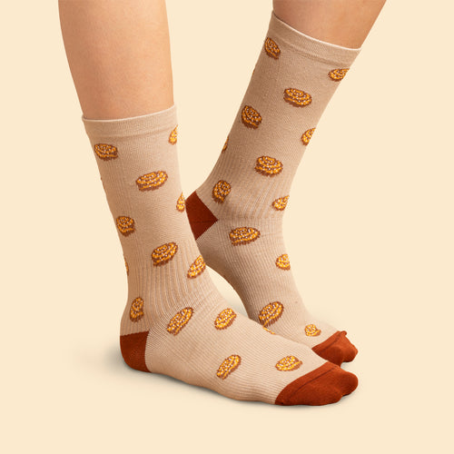 Beige stödstrumpor i sneakersmodell med mönster av kanelbullar och bruna detaljer från Svenskhusman.