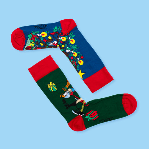 Blå och gröna julstrumpor prydda med Pippi Långstrump-motiv och röda detaljer från Svenskhusman.