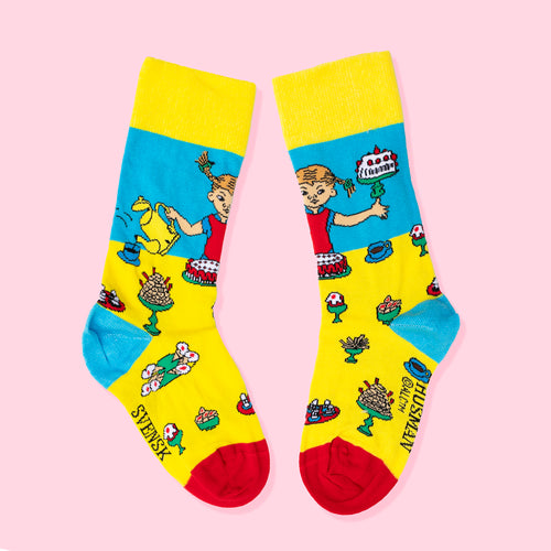 Gula och blå barnstrumpor med mönster av Pippi Långstrump på kalas och festliga motiv från Svenskhusman.