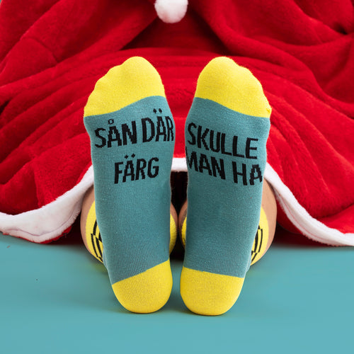 Julstrumpor med citatet "Sån där färg skulle man ha" i blått och gult från Svenskhusman.