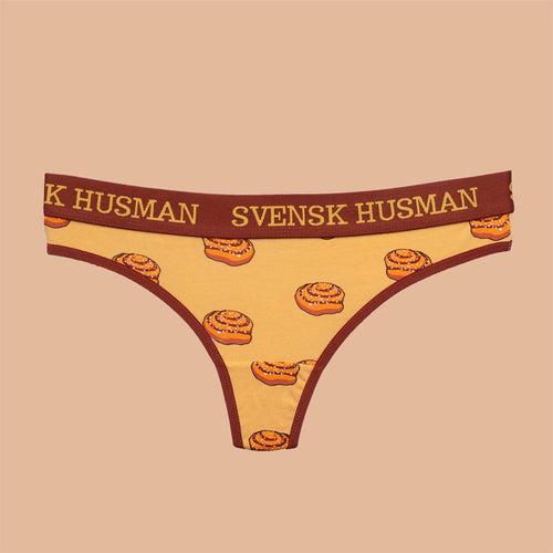 Bruna stringtrosor i mjuk bomull med mönster av kanelbullar och logotyp på resårbandet.