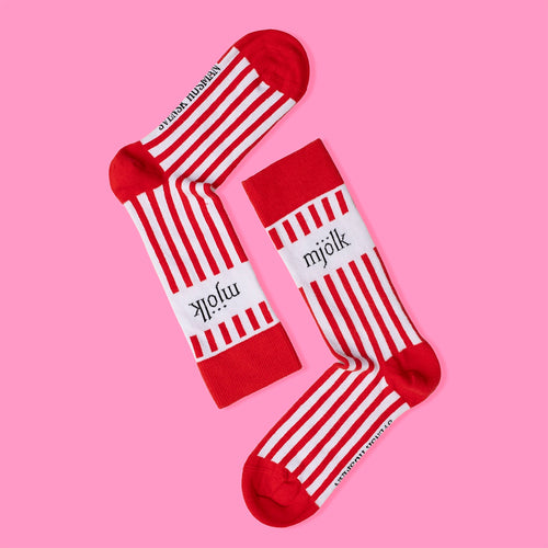 Rödvita randiga strumpor med texten mjölk på rosa bakgrund från Svenskhusman.