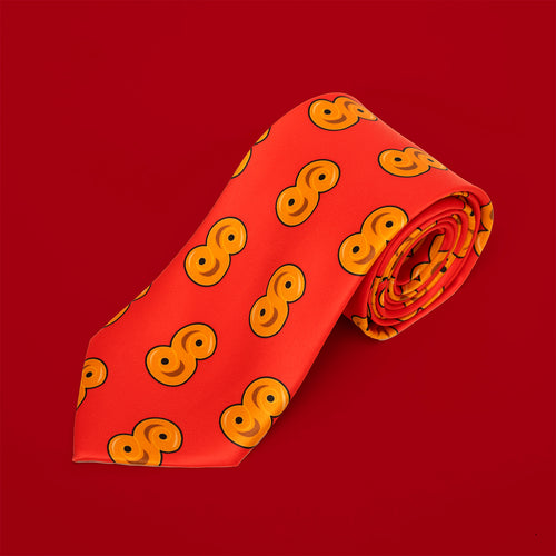 Röd slips i polyester med mönster av gula lussebullar rullad på en röd bakgrund, Svenskhusman.