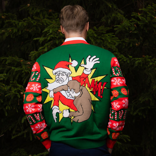 Jultröja i grönt med Tomtejävel-motiv på ryggen, buren av en man i skogsmiljö från Svenskhusman.