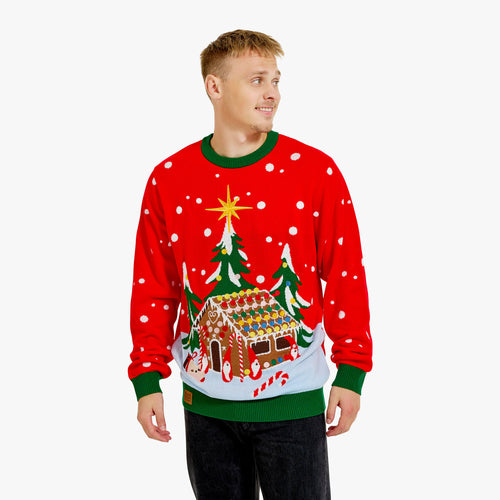 Stickad röd jultröja för herr med motiv av ett pepparkakshus och snöiga granar från Svenskhusman.