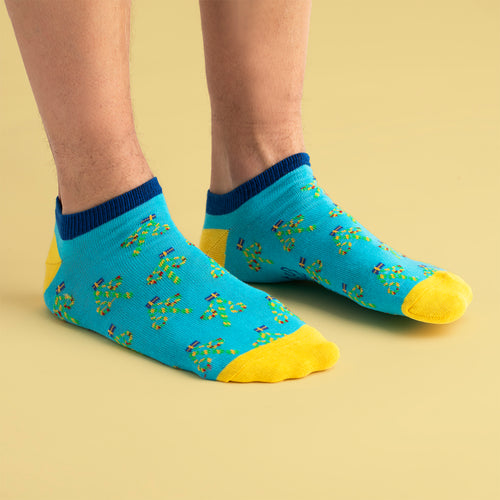 Sneakersstrumpor i ljusblått med motiv av midsommarstänger och gula tår från Svenskhusman.