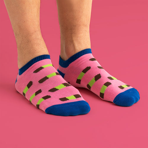 Rosa sneakersstrumpor med mönster av dammsugare och blå detaljer på fötter mot rosa bakgrund.