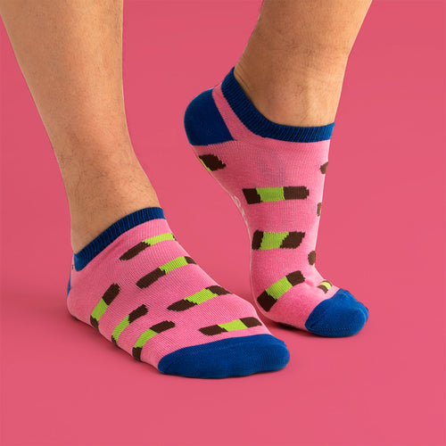 Rosa sneakersstrumpor med mönster av dammsugare och blå detaljer på en person från Svenskhusman.