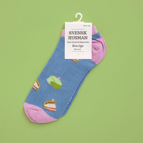 Ljusblå sneakersstrumpor med mönster av prinsesstårtor och rosa detaljer från Svenskhusman.