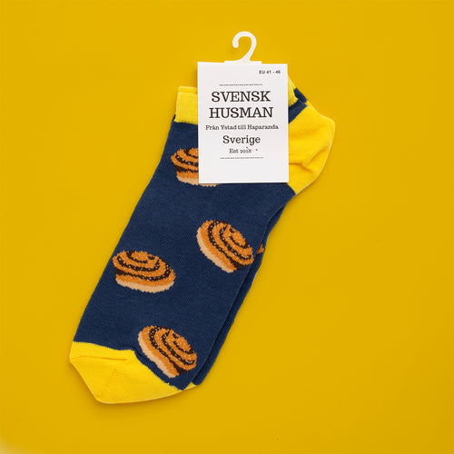 Blå sneakersstrumpor med gula detaljer och mönster av kanelbullar från Svenskhusman.