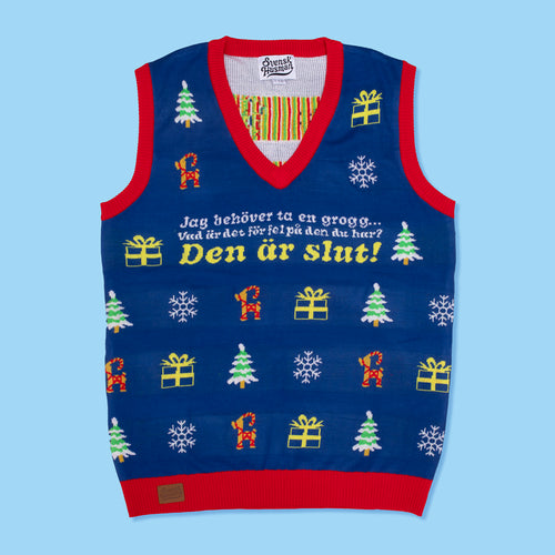 Blaue gestrickte Weihnachtsweste mit roten Rändern, dem Text „Jag behöver ta en grogg“ und Motiven von Svenskhusman.