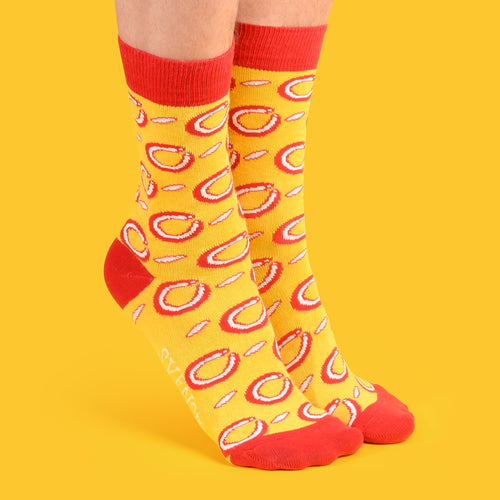 Yellow cotton socks with a red Falu sausage pattern and red accents on a yellow background by Svenskhusman.