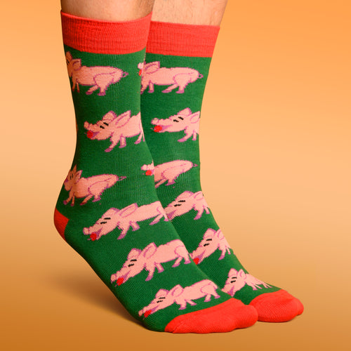 Gröna julstrumpor med mönster av rosa julgrisar med äpplen och röda detaljer från Svenskhusman.