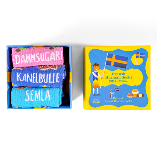 Fika-presentbox med tre par strumpor föreställande kanelbulle, semla och dammsugare från Svenskhusman.