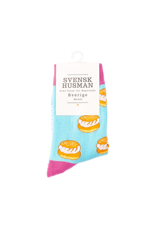 Türkise Kindersocken mit Semla-Muster und rosa Ferse in weißer Svenskhusman-Verpackung.