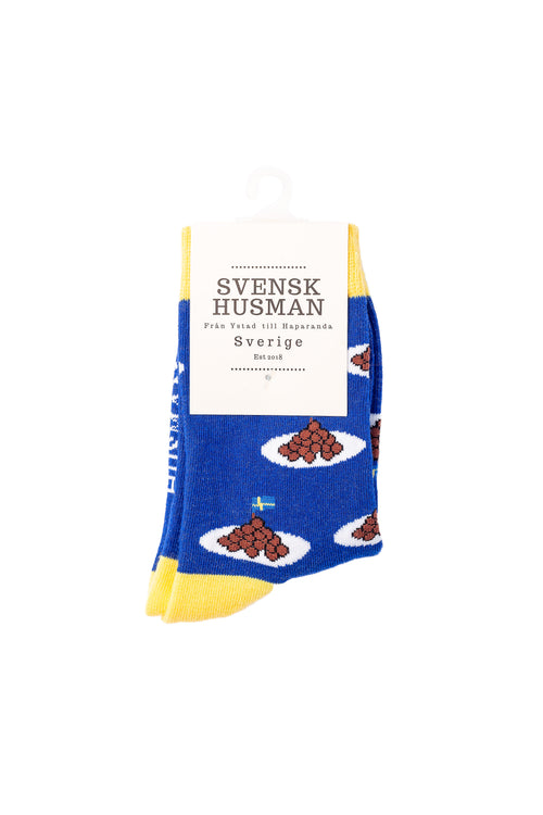 Blå barnstrumpor med mönster av köttbullar på tallrik och gula detaljer från Svenskhusman.
