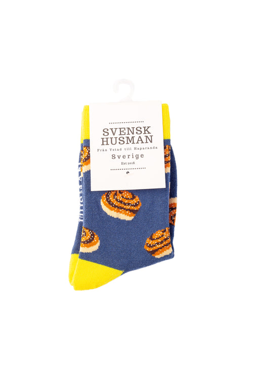 Blå barnstrumpor med mönster av kanelbullar och gula detaljer från Svenskhusman.